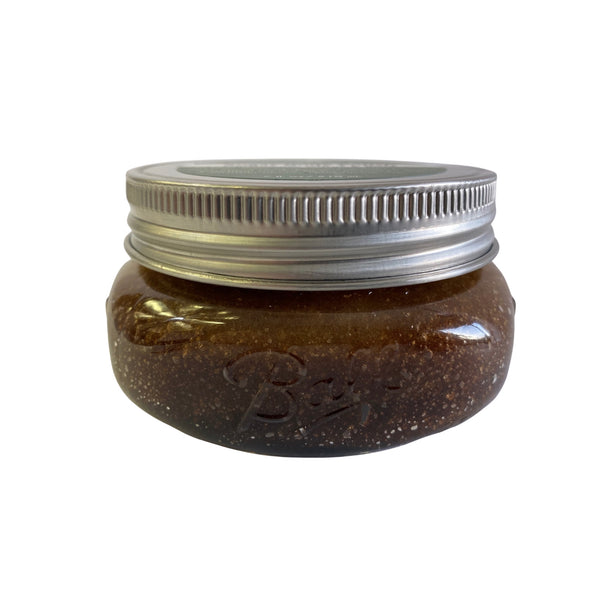 Side view of sugar body polish with cardamom, citrus, and rose essential oils, 7-ounces in clear glass mason jar with stainless steel lid
